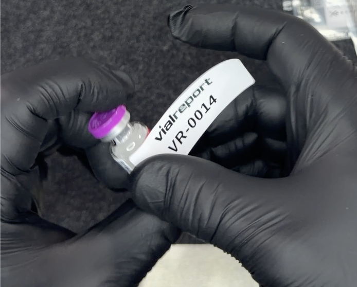 The opaque blind-code label going on over the vendor label